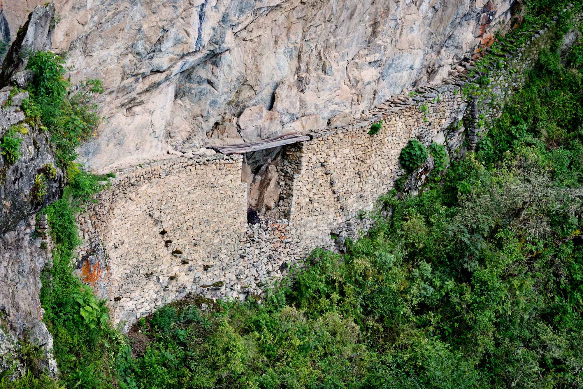 Historic Inca Bridge built into the cliff at Machu Picchu, Peru.